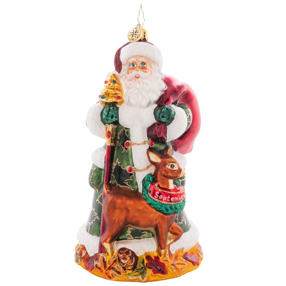 Ornament Description - Autumn Colors: The ninth piece in our Ornament of the Month collection celebrates autumn! Festive as ever for the fall harvest, Santa is sporting a lovely leaf-covered cloak.