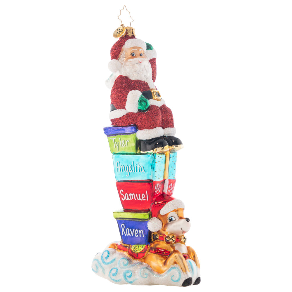 Ornament Description - Santa Parade: St. Nick sits atop a tall stack of brightly-wrapped gifts that spell out the New Year. He waves to his fans while his trusty reindeer works it for the Yuletide parade crowd. Personalize this treasure by adding the names of your family members to each gift. Note: Please allow approximately one month (on top of shipping time) for our elves to personalize your ornament.