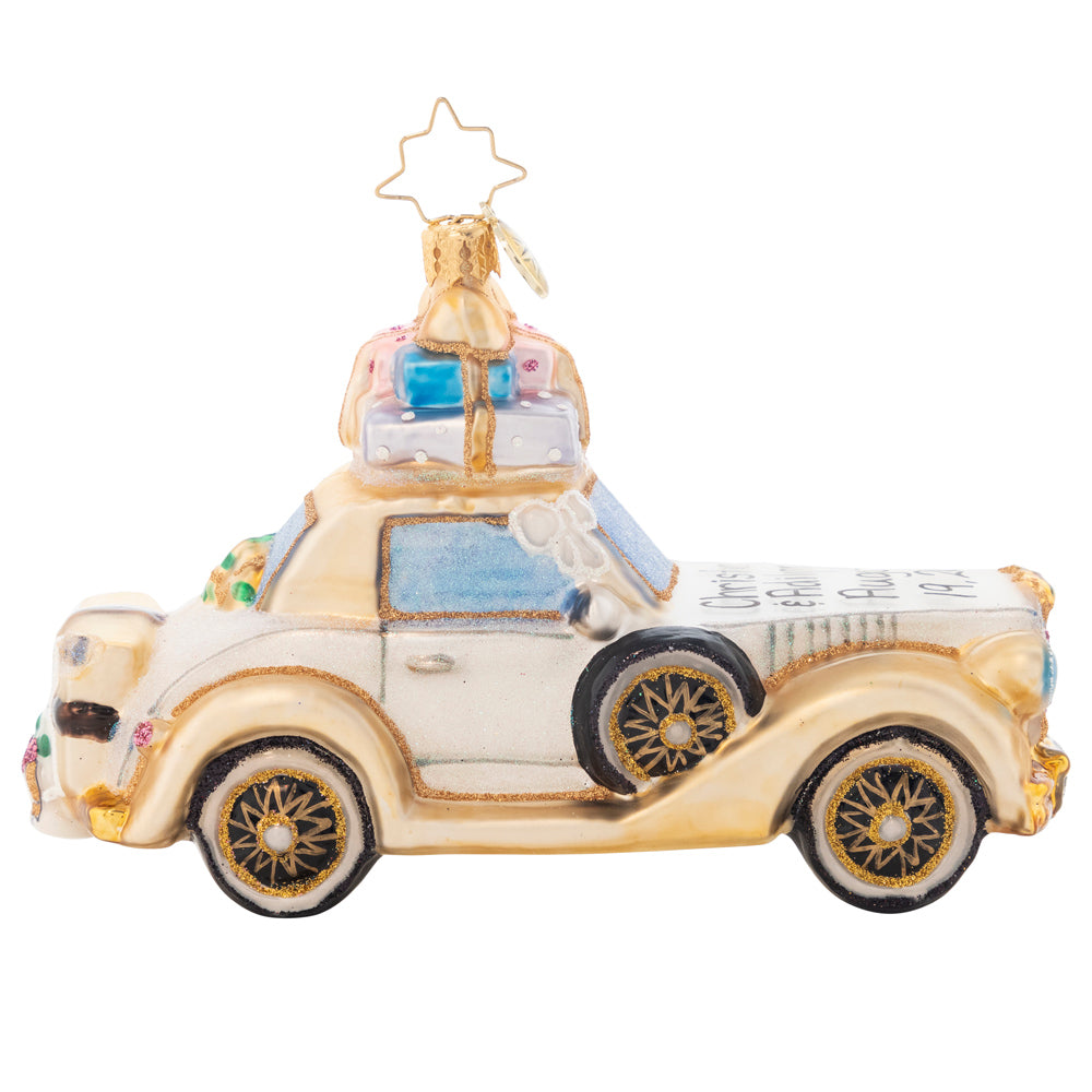 Side View - Ornament Description - Wedding Bliss Chariot: The happy couple takes off after their wedding in this wedding bliss chariot! Their gifts stacked high atop the roof and their bags packed for a honeymoon of memories at the back, this loving couple is ready for their happily ever after! Note: Please allow approximately one week (on top of shipping time) for our elves to personalize your ornament.