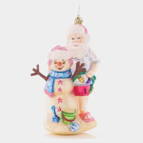 Video - Ornament Description - Sandy Snow Team: Hang back with this Santa on the beach as the waves are in reach. Build a sandyman as best as you can, to create a cheery team with a Christmas plan. This video shows the ornament spinning slowly. 